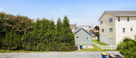 A residential area with houses, a driveway, and a parked car.