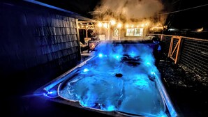 A hot tub with blue lighting and steam rising from the water.