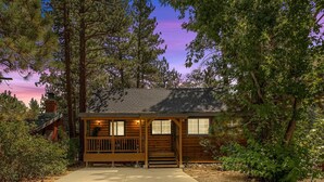 A rustic cabin with a front porch, surrounded by trees and a clear sky. - Cozy Cabin, A/C, Hot Tub, Tankless Water Heater, Jacuzzi, Full Kitchen (Big Bear Lake)