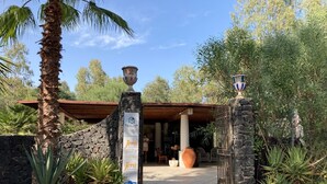 Una entrada de piedra con un cartel de Vulcano Terme Residence, un porche cubierto y un camino que lleva a un edificio.