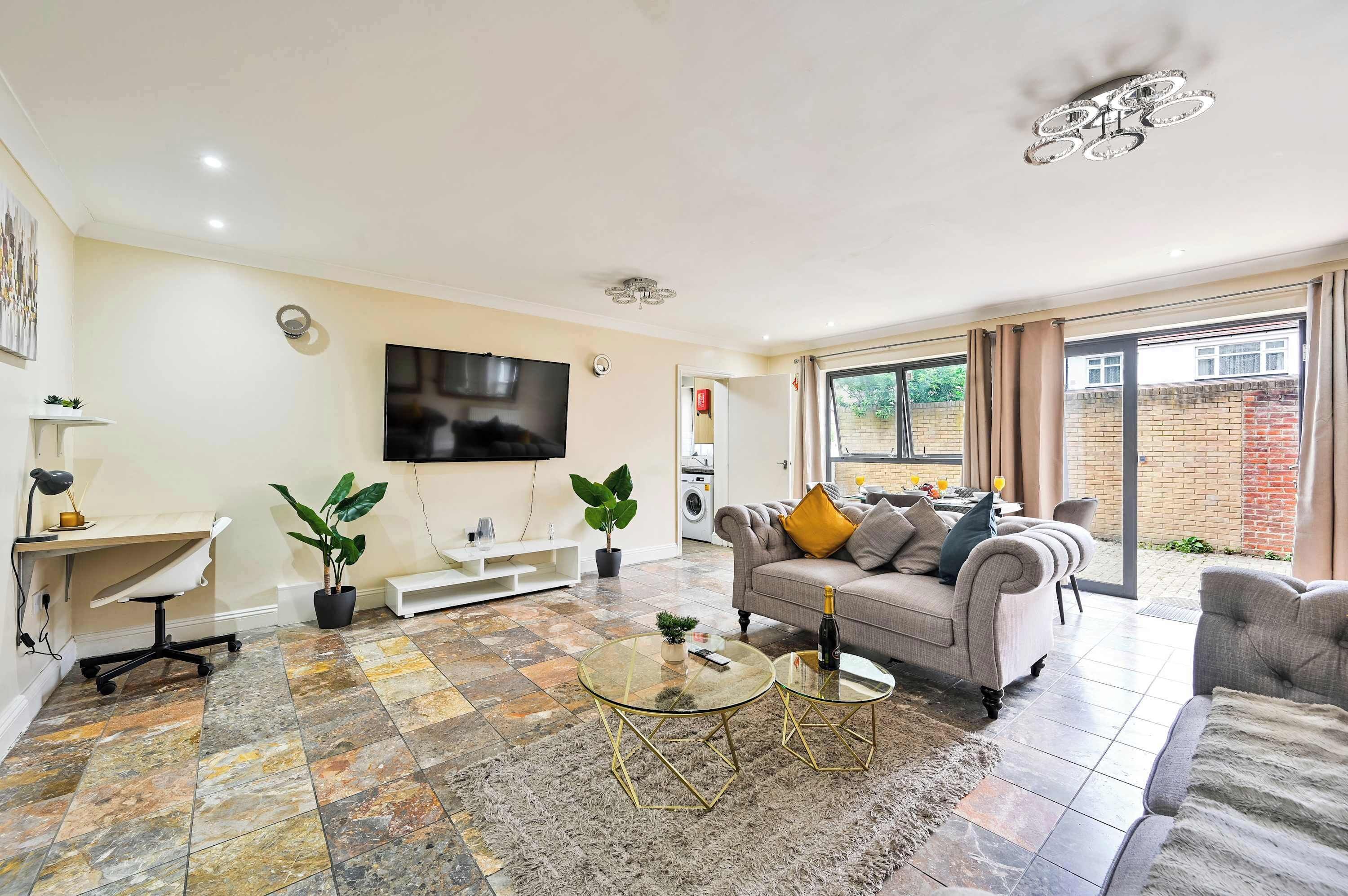 A living room with a sofa, coffee table, TV, and a view to the outside.