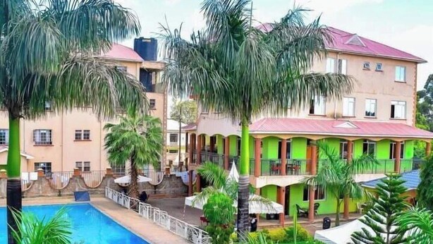 A hotel with a swimming pool, surrounded by palm trees and greenery. - Hotel Vannah (Migori)