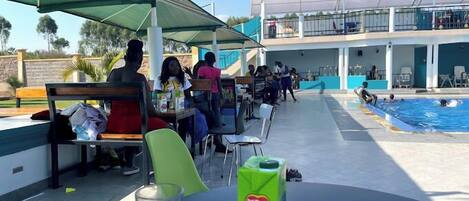 A poolside area with outdoor seating and a pool.
