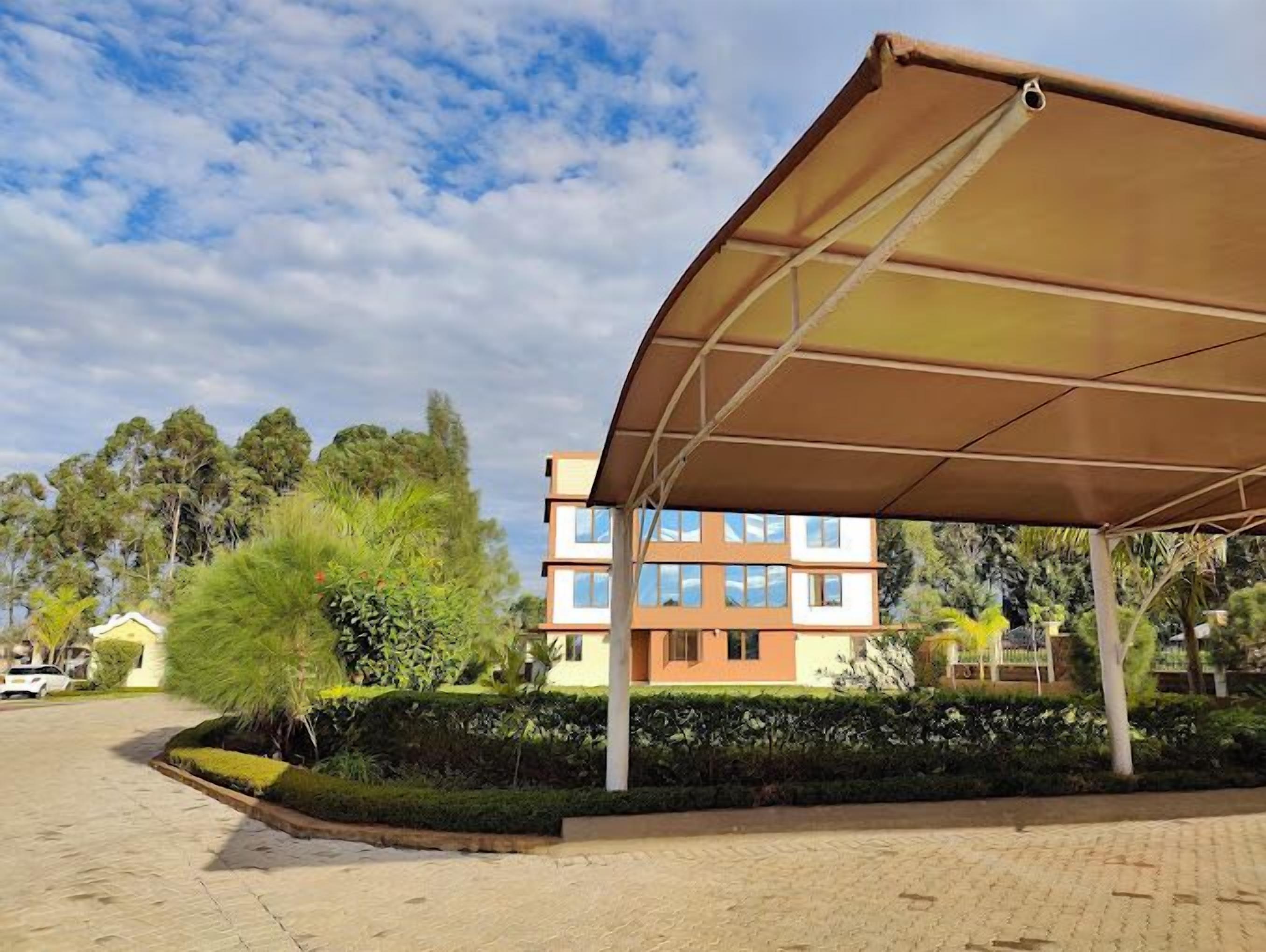 A covered outdoor area with a building in the background.