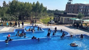 A swimming pool with multiple lanes and people swimming and playing.