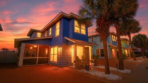 Une maison à deux étages avec un garage, de grandes fenêtres et une entrée bien éclairée.
