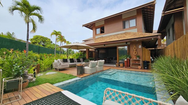 A modern house with a swimming pool, outdoor furniture, and lush greenery. - Casa Marluá (Camacari)