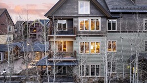 A multi-story residential building with a prominent balcony on the second floor, a large window on the third floor, and a visible entrance with a door. - Steps to Lifts, Peak 9, Main Street Balcony, Lounge Pool Water House 5204 by Avantstay (Breckenridge)
