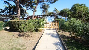A pathway leading to a wooden gate with a sign that reads "Casa Negra IMMOBILIER."