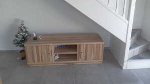 A staircase with a wooden console table beneath it, a small potted plant, and a sign on the table. - 1 bedroom apartment in marigot (Marigot)