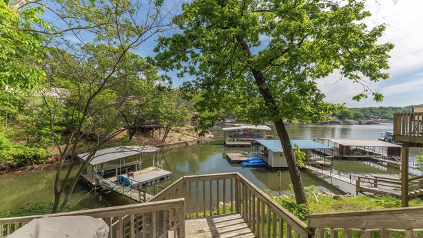A riverside dock with wooden walkways and a covered seating area.