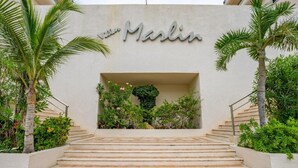 Eine Treppe führt zu einem Gebäudeeingang, an dem ein Schild mit der Aufschrift 'Marlin' hängt.