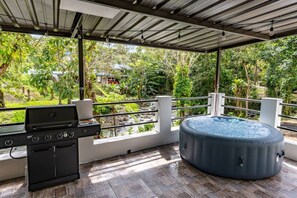 Un patio al aire libre con una parrilla y un jacuzzi.