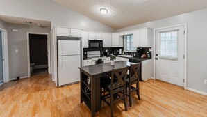 A kitchen with white cabinets, a central island, and a refrigerator. - Spacious 3bd/2ba near Casino (Danville)