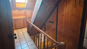 A wooden staircase with a handrail, leading to a room with a window and a skylight. - Lots of space & comfort - ideal for fitters or vacation guests! (Orbis)
