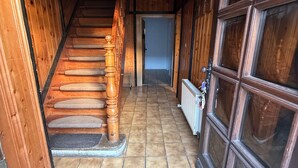 A wooden staircase leading to a door with a glass panel, a radiator, and a tiled floor. - Lots of space & comfort - ideal for fitters or vacation guests! (Orbis)