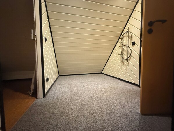 A small, enclosed room with a sloped ceiling and a carpeted floor. - Lots of space & comfort - ideal for fitters or vacation guests! (Orbis)
