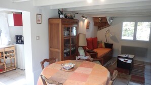 A cozy living area with a dining table, a sofa, and a cabinet.