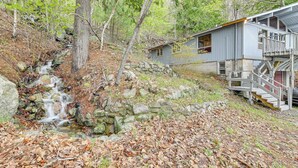 Eine Holzhütte mit einer Steinmauer und einem kleinen Wasserfall.