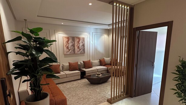 A modern living room with a sofa set, a coffee table, and a large potted plant. - Luxury Apartment in Central Marrakech - Pool & Fast Wi-Fi (Marrakesh)