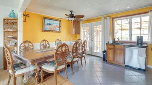 A dining area with a wooden table and chairs, a ceiling fan, and a kitchen area with a sink and cabinets. - Deck & Dock: Home in Little Egg Harbor Township (Little Egg Harbor Township)