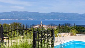 Une piscine avec vue sur la mer et les montagnes.