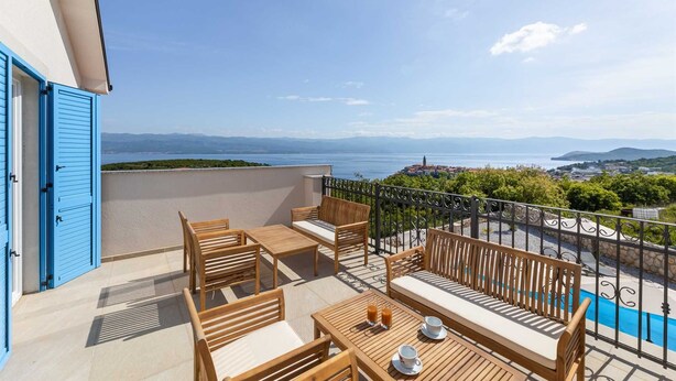 A balcony with wooden furniture and a view of the sea. - Villa Maja– Stylish Oasis with Heated Pool & Sea View (Vrbnik (Krk))