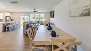 Una cocina amplia con comedor, un gran ventanal y un ventilador de techo.