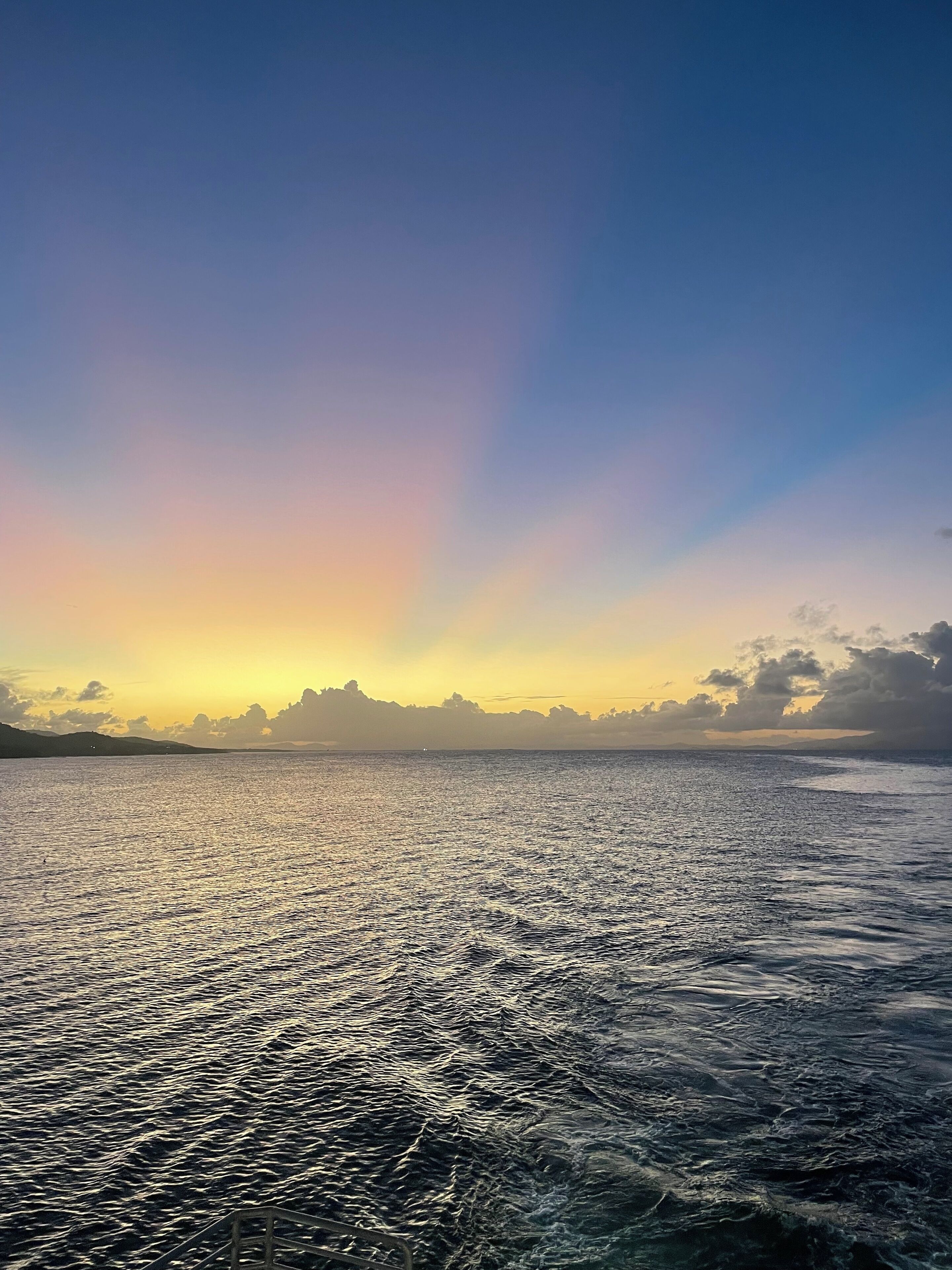 Une mer calme sous un ciel dégagé, au coucher du soleil.