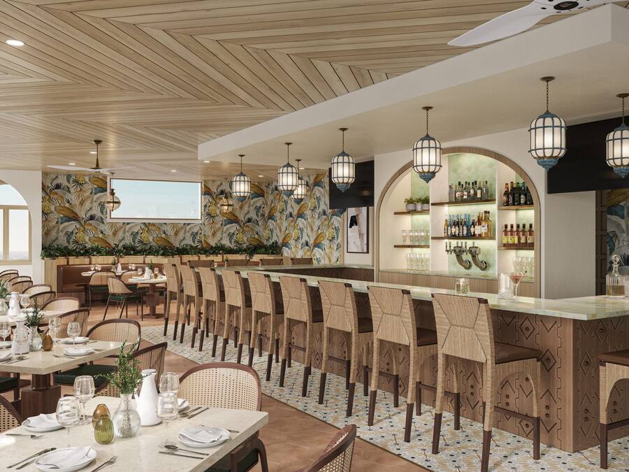 Un restaurante con techos altos de madera, una zona de bar con estanterías llenas de botellas y un comedor con mesas y sillas.