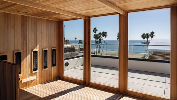 Interior de madera con grandes ventanales con vistas a una playa.