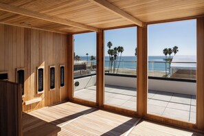 A wooden interior with large windows overlooking a beach. - La Bahia Hotel and Spa (Santa Cruz)