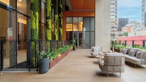 Un'area esterna moderna con un angolo relax e un giardino verticale.