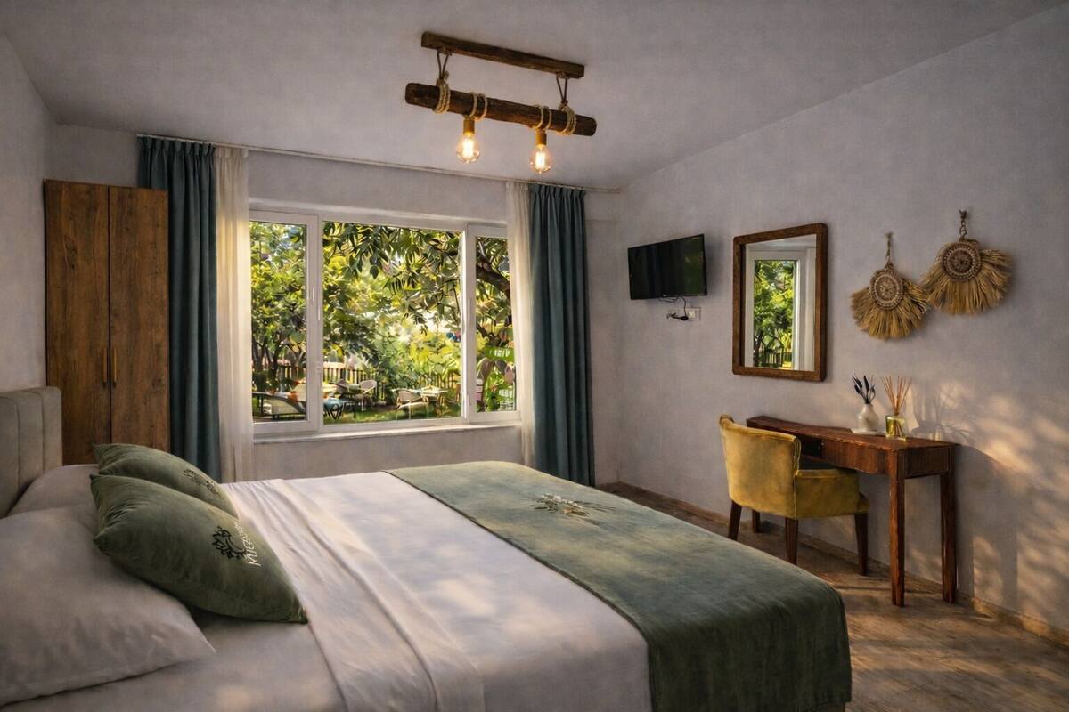 A bedroom with a bed, a desk, a TV, and a window with curtains.