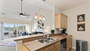 A modern kitchen with a central island, stainless steel appliances, and pendant lighting.