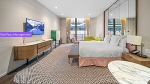 Un hotel moderno con una cama grande, televisión, escritorio y vistas a la ciudad.