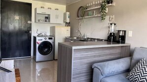 A compact kitchen with a built-in island, a washing machine, and a coffee maker. - Exotic family getaway (Armenia)