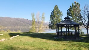 A gazebo by a lake with a clear view of mountains in the background. - Condo Near Snowbasin, 2/2 (Huntsville)