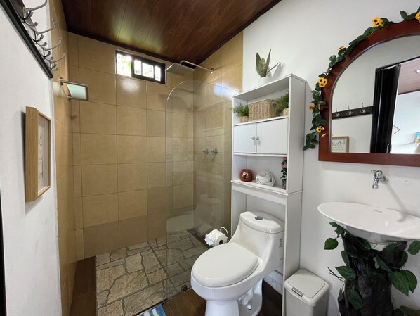 A bathroom with a shower, toilet, and sink.