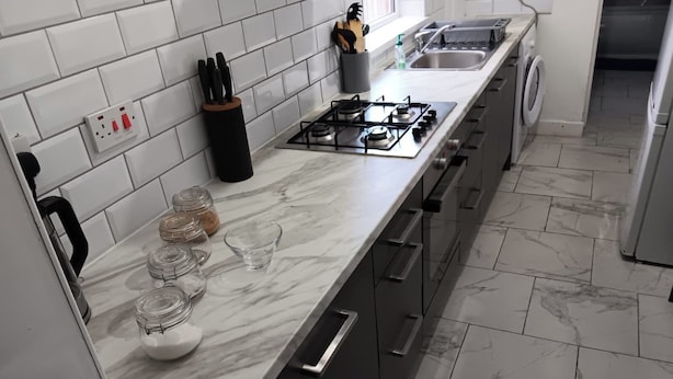 A modern kitchen with a marble countertop, a gas stove, a sink, and a dishwasher. - 4 Bed-sleeps 9-private Garden-free Parking (Birmingham)
