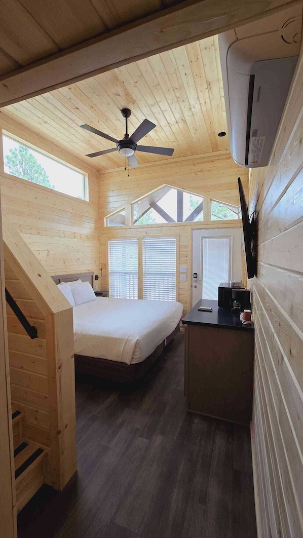 Cozy cabin with a bed, desk, and chair, perfect for a peaceful retreat.
