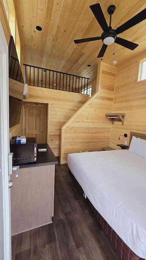Cozy retreat with a bed, desk, and window.