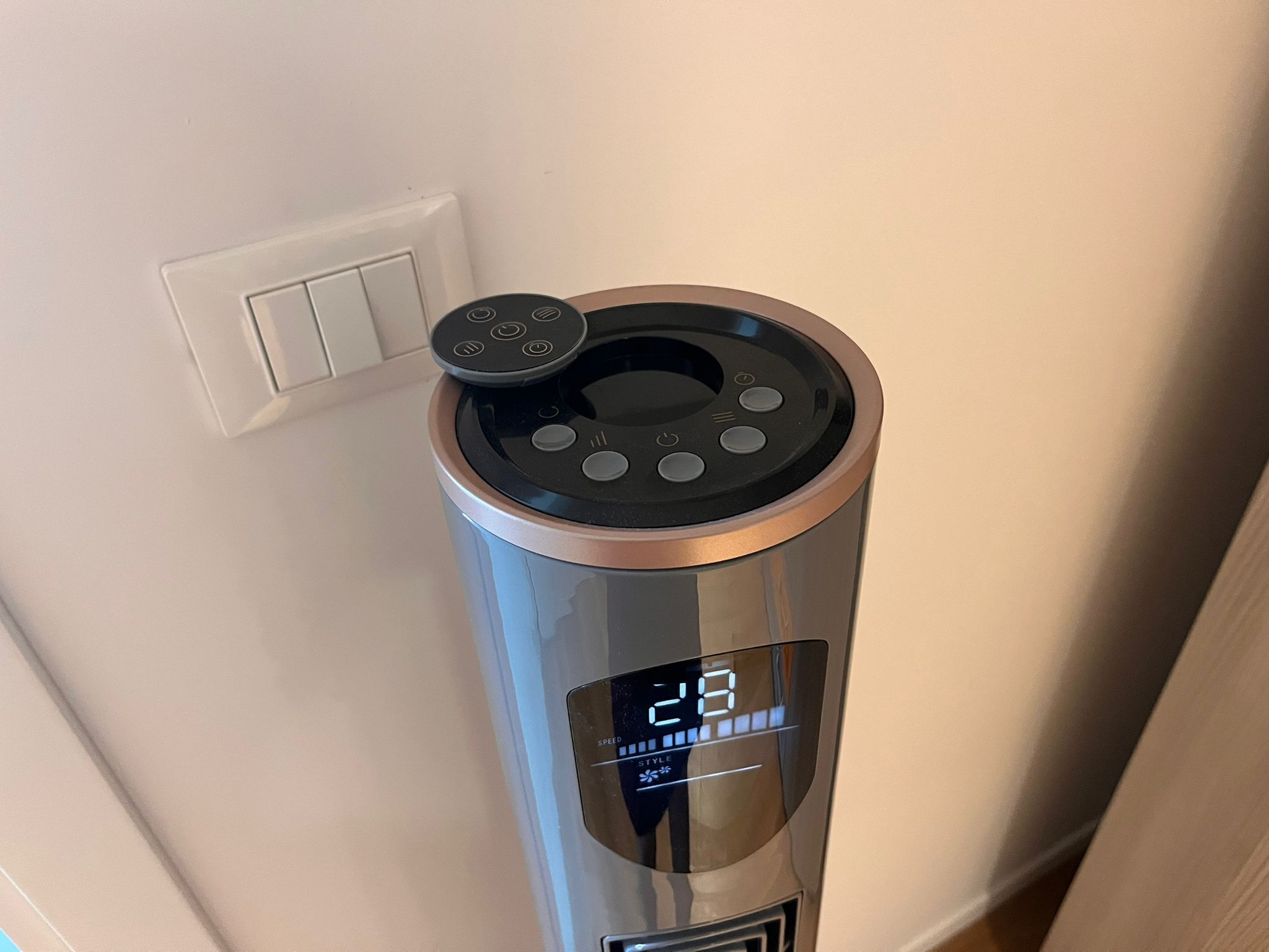 A cylindrical device with a digital display, control buttons, and a power outlet nearby.