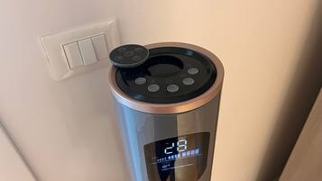 A cylindrical device with a digital display, control buttons, and a power outlet nearby.