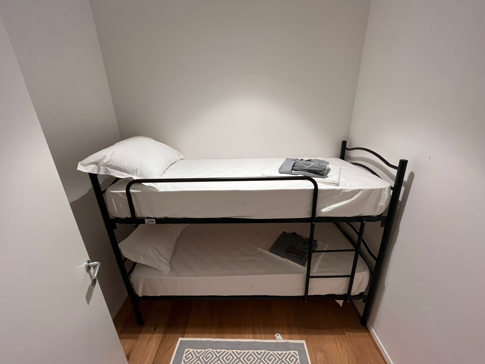 Una cama litera con una almohada y una bolsa en la parte superior.