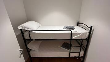 Una cama litera con una almohada y una bolsa en la parte superior.