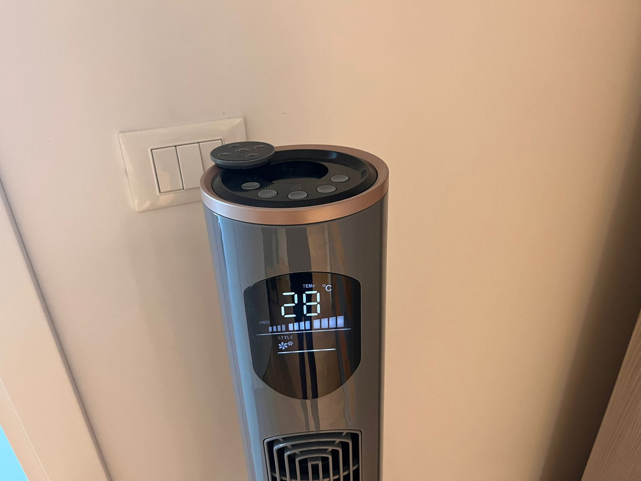 Un distributeur d’eau cylindrique en métal, doté d’un écran numérique indiquant 28 °C, d’un réglage de la vitesse et d’un bouton permettant de choisir le type de distribution.