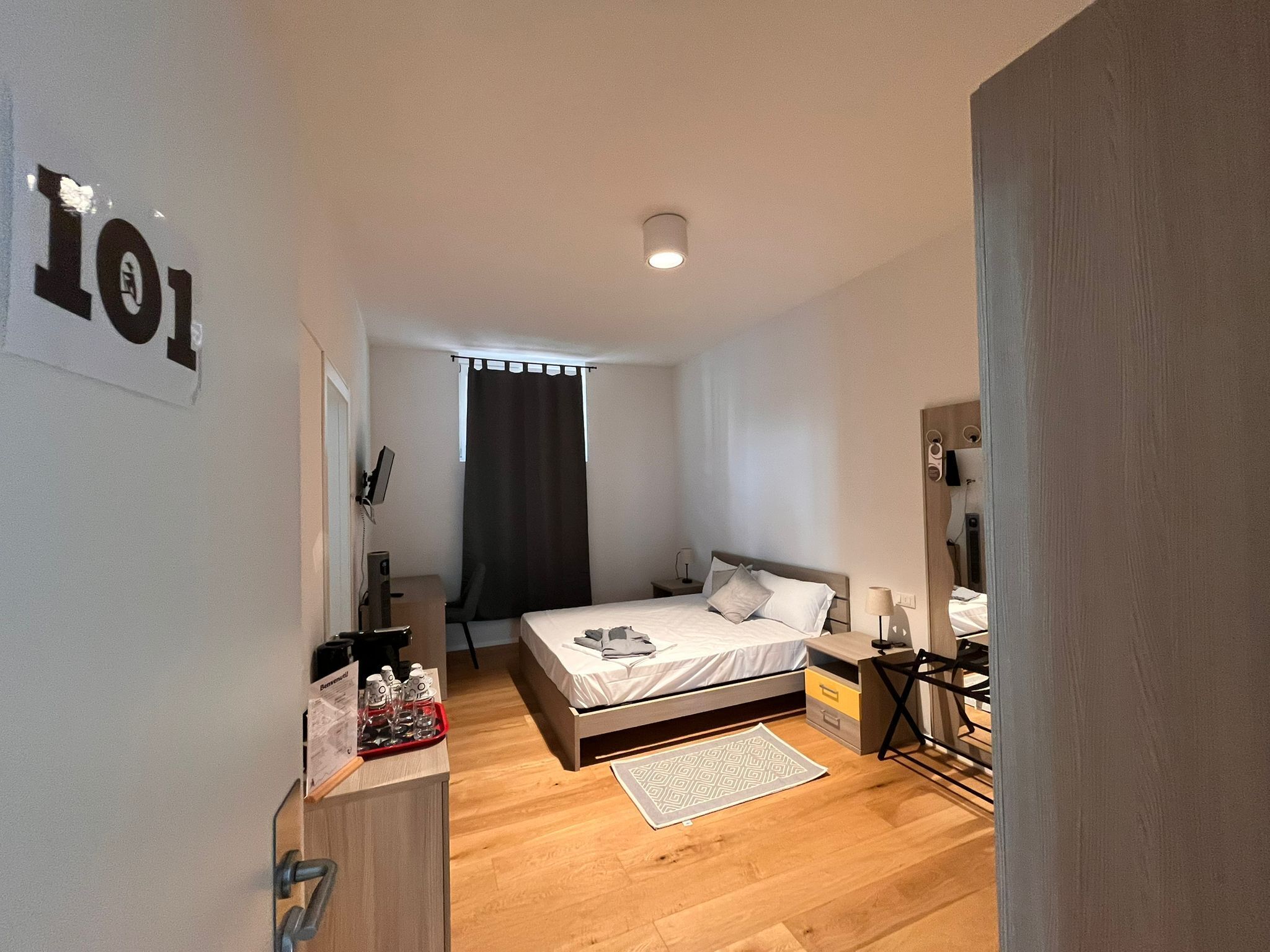 Un dormitorio moderno con cama, mesitas de noche, un escritorio y un armario.
