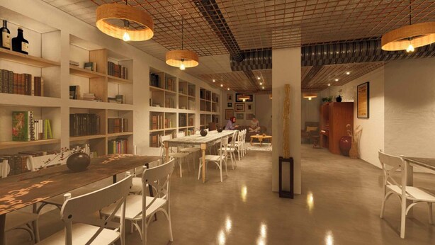 A spacious library with high ceilings, bookshelves, and a central table with chairs. - Terra Buona Rooms (Traona)