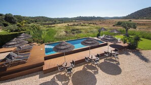 A pool area with lounge chairs and umbrellas, surrounded by a landscaped garden and a view of the countryside. - 1 bedroom apartment in estã´mbar (Estômbar)